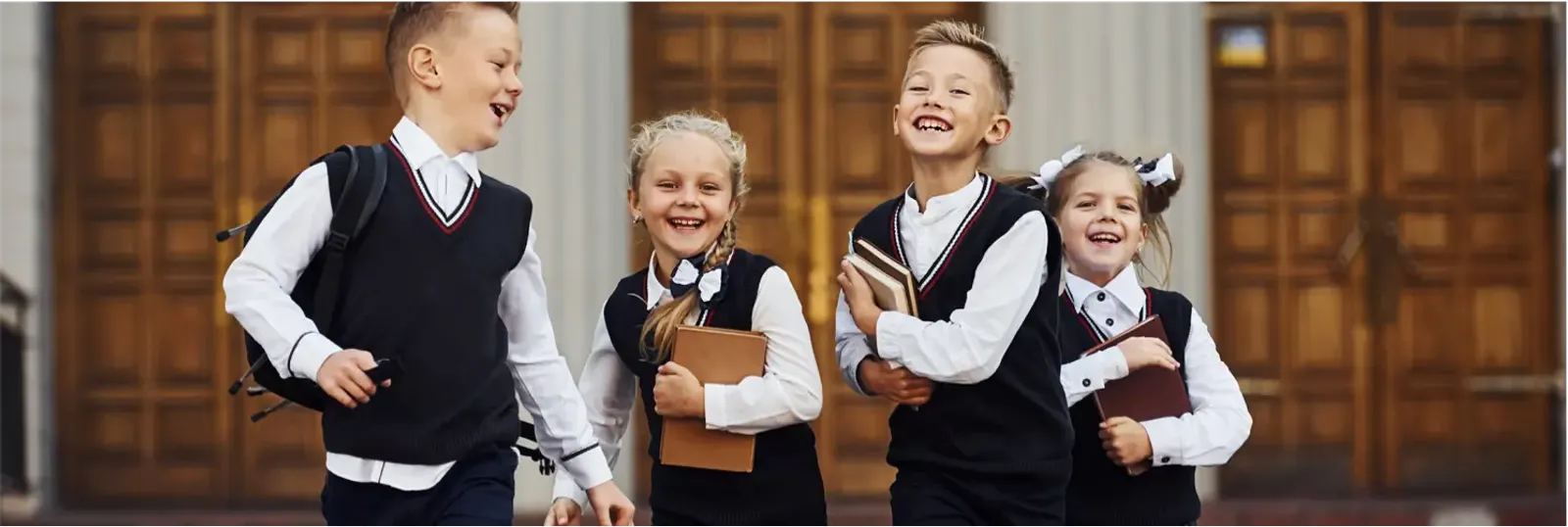 Group of children in black sweater uniforms with white shirts.