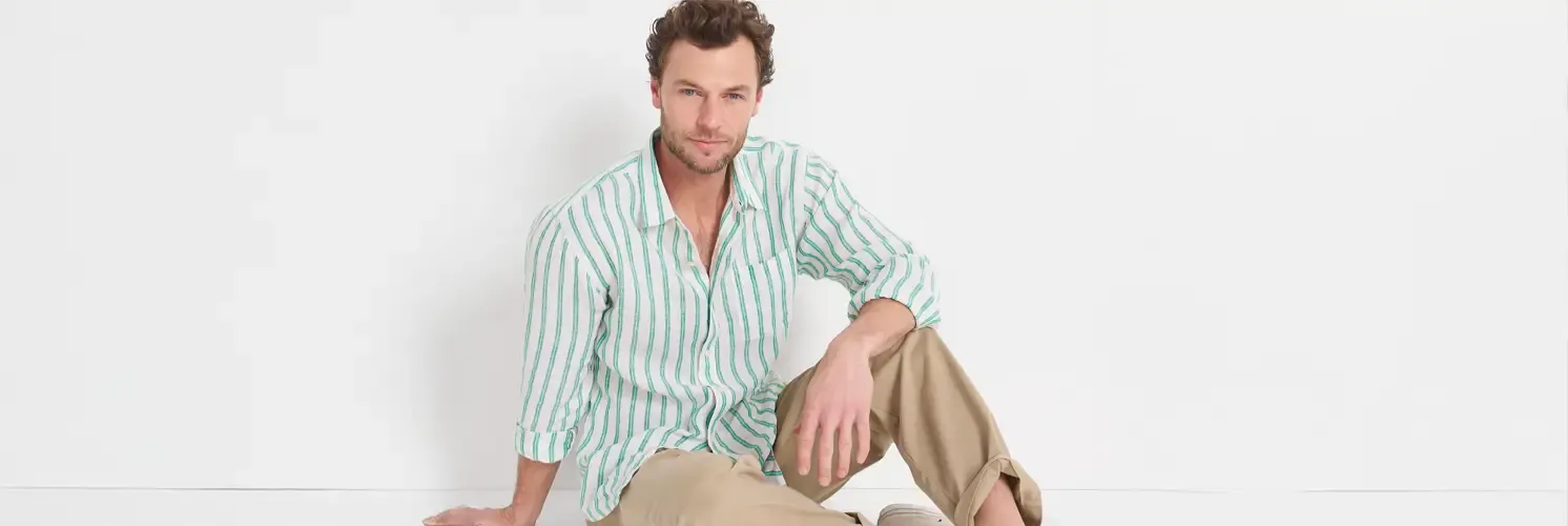 Man wearing a white and mint-green striped linen shirt and khakis.