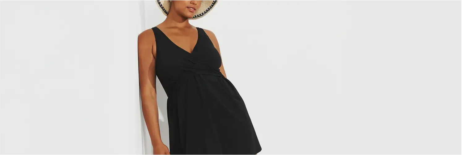 Woman wearing a sleeveless black dress and a straw hat.