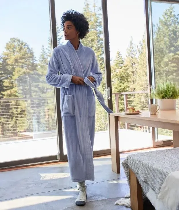 Woman wearing a blue bathrobe and thick socks.