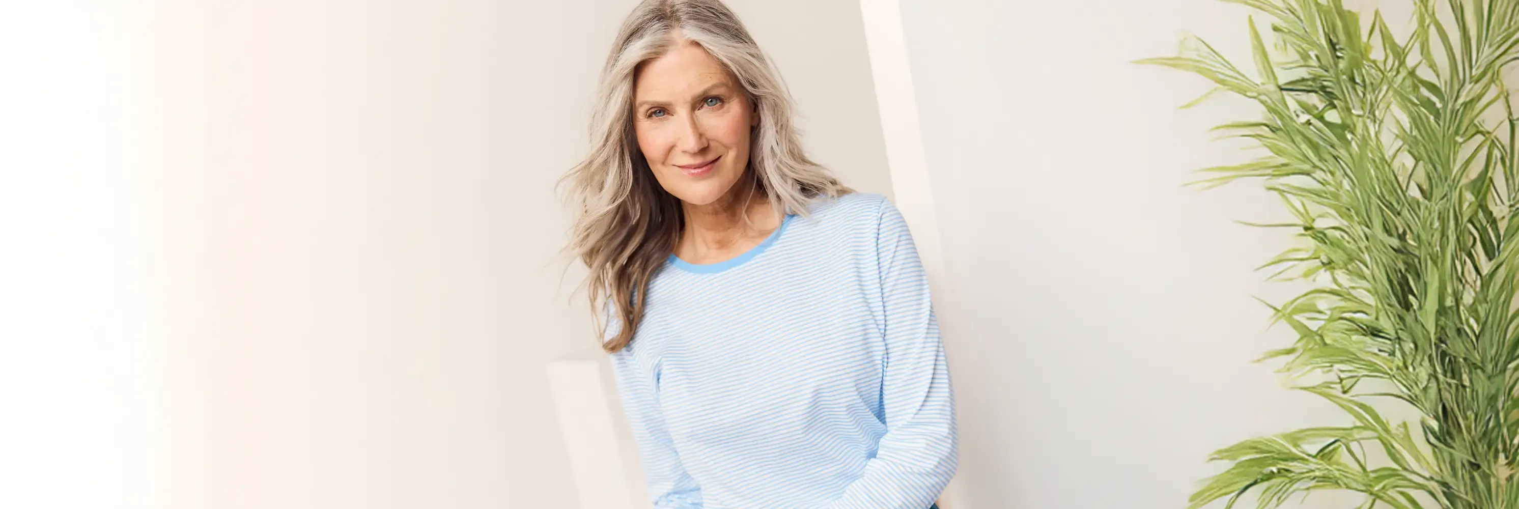 Woman wearig a light blue striped long-sleeve top.