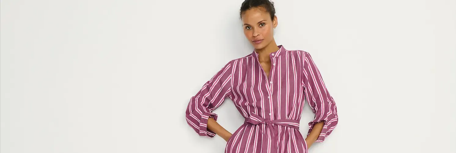 Woman wearing magenta and white striped belted dress.