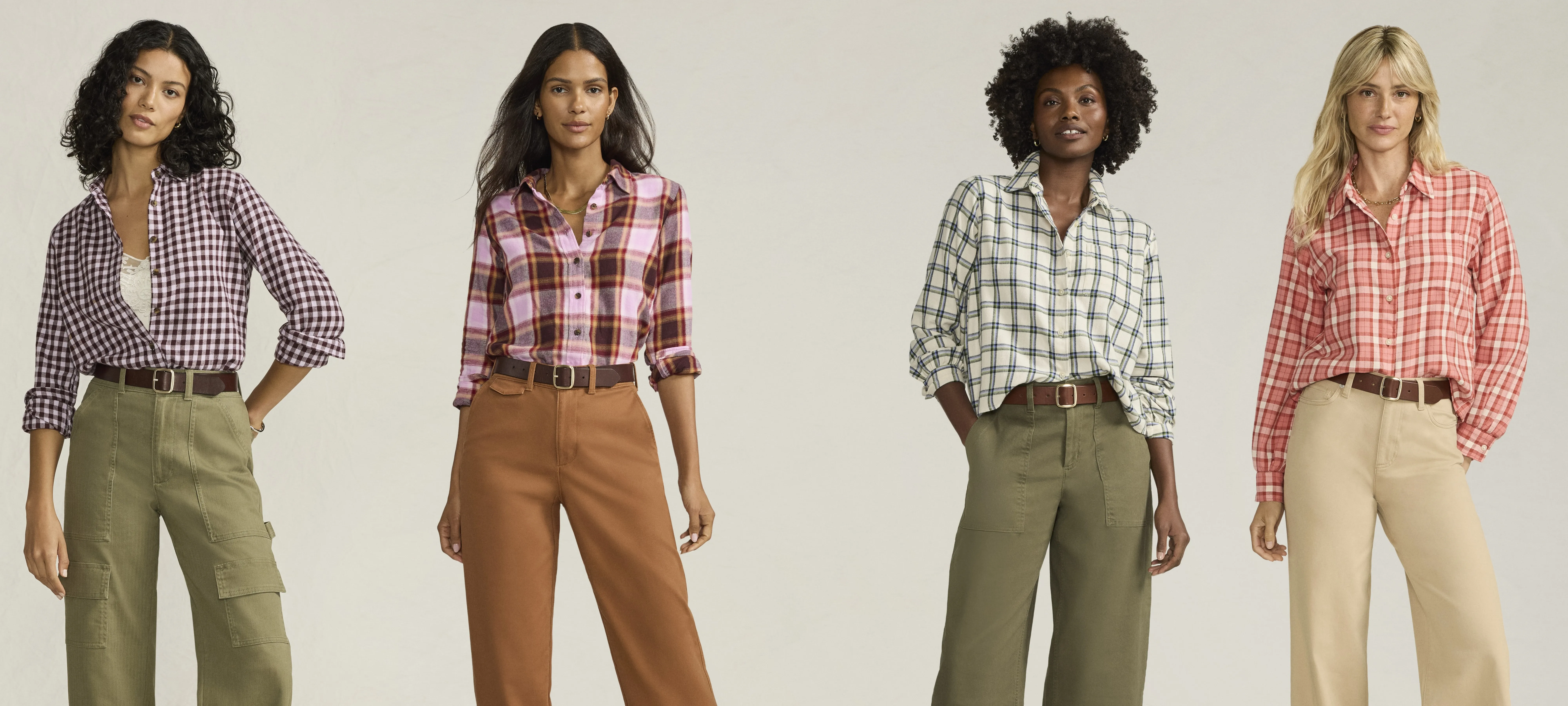 Four friends dressed in plaid shirts and khaki pants.