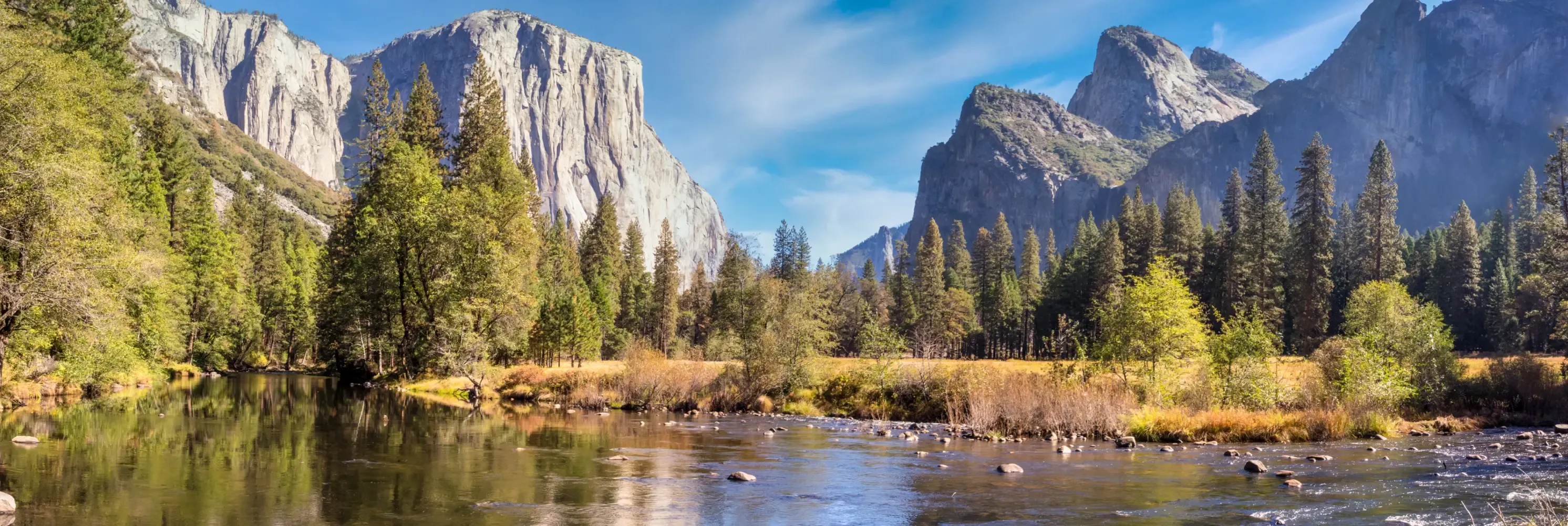 River flowing through a forested valley beneath El Capitan.